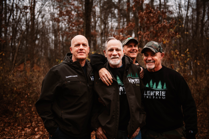 Four consulting foresters standing in a grove of trees